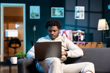 Businessman working from home using laptop to send emails. Worker typing on notebook keyboard, composing documents in order to deliver finalized project paperwork to management clipart