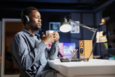 Müteahhit evde web yayını dinliyor ve serbest anlaşmalar çerçevesinde görevlerini yerine getirmek için yeni bir yaklaşım hazırlıyor. İnternet üzerinden verileri inceleyen Afrikalı Amerikalı serbest yazar.