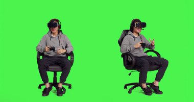 VR kulaklıkla yarışan genç adam yeşil ekranda oturuyor, joystick 'te video oyunlarının keyfini çıkarıyor. Asyalı oyuncu çevrimiçi roket yarışması ile eğleniyor, sanal gerçeklik eğlencesi.