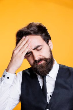 Acı verici baş ağrısı olan mutsuz işçi, tapınakları ovmak ve stüdyodaki restoran işinde çok çalışmak. Migren ağrısı çeken genç bir adam tükenmiş, sarı bir geçmişi var. Kapat..