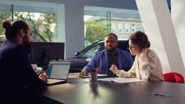 Araba galerisi satıcısı müşterileri satın almaya ikna etmek için rekabetçi kiralama gibi esnek finansal seçenekler sunuyor. Araç galerisi temsilcisi müşterileri sunar anlaşmaları finanse eder, kamera B