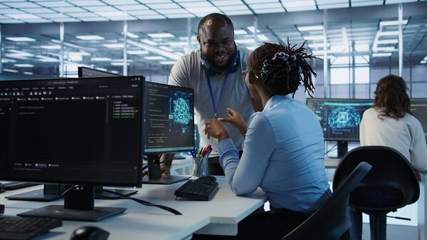 Manager doing team meeting with engineers, delegating tasks in high tech data center office. Supervisor doing brainstorming with IT experts how to while monitor AI supercomputers, camera B