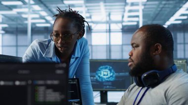 Yüksek teknoloji veri merkezi tesisinde meslektaşıyla birlikte çalışan mühendis donanım enerji tüketimini izliyor. Sistem arızalarını kontrol etmek için bilgisayar kullanan teknisyen ekibi, kamera A