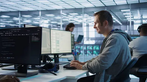 Sunucu merkezinde çalışan ve büyük miktarda veri işleyebilen bir adam. Klavyeye yazı yazan bilgisayar programcısı, ağ kaynaklarını kontrol eden sunucular güncelleniyor, kamera B