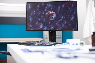 Mikroskobik mikropları gösteren bilgisayar monitörlerinin kapatılması, hastalık araştırmalarında sağlık teknolojisinin önemini vurguluyor. Boş doktor ofisindeki dijital kurulum hastanın tıbbi bakımını destekler.
