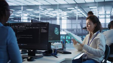 Makine öğrenme eğitimi için kullanılan yapay zeka veri merkezindeki mühendislik programının proje sürecini denetleyen yönetici. Takım lideri, yapay zeka teknolojisi ve B kamerasıyla ilgili evrakları okuyor.