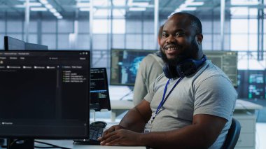 Yüksek teknoloji işyerinde çalışan neşeli teknisyenlerin portresi farklı iş yükleri için bilgisayar kaynakları sağlıyor. Veri merkezi ana bilgisayarlarını izlemekle görevli ışıl ışıl bilişim uzmanı, kamera A