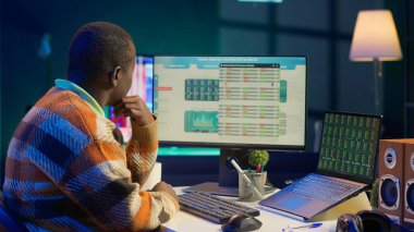 Afrikalı Amerikalı analist mali dengeyi kontrol ediyor ve muhasebe analizi üzerinde çalışıyor. Yurtiçinde girişim geliri elde etmenin yollarını araştırıyor. Ekonomi istatistiklerini kullanarak uzaktan çalışma danışmanı. Kamera A.