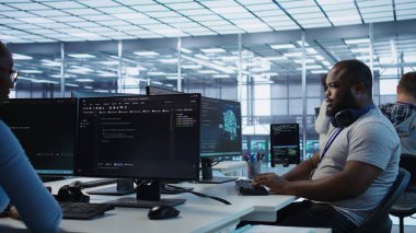 Veri merkezinde çalışan mutlu bilgisayar bilimci farklı iş yükleri için hesaplama kaynakları sağlıyor. Neşeli bilişim uzmanı, tablet ve kamera B kullanarak yüksek teknolojili süper bilgisayarları izliyor.