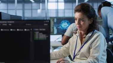 Yüksek teknoloji işyerinde çalışan neşeli teknisyen farklı iş yükleri için bilgisayar kaynakları sağlıyor. Veri merkezi süperbilgisayarlarını izlemekle görevli rahat kadın, kamera A