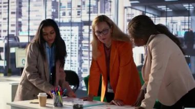 Genel müdür, şirketini küresel çapta genişletmeye çalışan başarılı bir kalkınma planı için ekibiyle birlikte veri analizlerini gözden geçiriyor. Toplantıda harika liderlik becerileri gösteren kadın bir CEO. Kamera A.