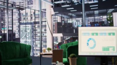 Toplantılarda kullanılan, detaylı analiz ve grafikleri çalıştıran bir monitörün finansal verileriyle modern ofis alanı. Başarı ve üretkenlik araçları için iş stratejileri geliştirmek için boş çalışma alanı.