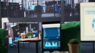 Toplantılarda kullanılan, detaylı analiz ve grafikleri çalıştıran bir monitörün finansal verileriyle modern ofis alanı. Başarı ve üretkenlik araçları için iş stratejileri geliştirmek için boş çalışma alanı.