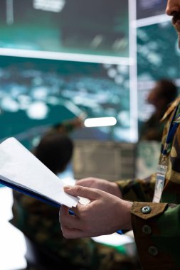 Askerler dava dosyasındaki çok gizli operasyon detaylarını inceliyor. Savunma görevinin başarıya ulaşmasını sağlamak için önemli savaş alanı verilerini inceliyor. Komuta merkezinde bir süvari var. Kapat..