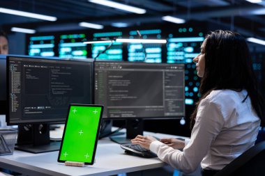 Veri merkezindeki bilgisayar bilimcileri, geliştirme makinelerinden sonra yeşil ekran tabletindeki ekipman performansını kontrol ediyorlar. Sunucu odasında krom anahtar aygıtı kullanarak platformların bakımını yapan yöneticiler