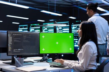 Yüksek bant genişliğinde bakım yapmak için yeşil ekran dizüstü bilgisayar kullanan teknisyen ekibi, dünya çapında konumlardan katılan çevrimiçi kullanıcıların gelen trafiğine uyum sağlamak için adanmış oyun sunucuları