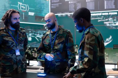 Bir hologram hakkında bilgi inceleyen çeşitli acemilerden oluşan bir ekip. Askeri karargahta federal CCTV uydu sistemi ile çalışıyorlar. Sanal projeksiyonla ilgili bilgi toplama etkinliği.