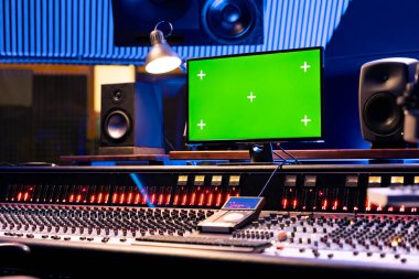 Kontrol masasının yanındaki bilgisayarda modelleme ekranı profesyonel ekipman ve ekipmanlarla boş müzik stüdyosu. Yapım sonrası için faders ve düğmeleri olan panel panosu.