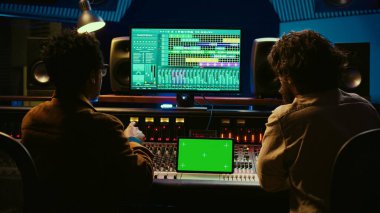 Sanatçı ve ses tasarımcısı, yeni albüm için bir hit besteleme üzerinde işbirliği yaparak dijital kurgu yazılımını ve tablet üzerindeki modellemeyi inceliyor. Stüdyoda ses teknisyeniyle çalışan bir müzisyen. Kamera B.