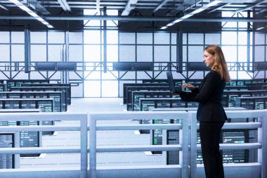 Veri merkezindeki mühendis donanımı ve altyapıyı kontrol ediyor, bakım yapıyor. Yüksek teknolojili sunucu merkezi göçü ve güncellemeleri dizüstü bilgisayar kullanarak planlama ve çalıştırma