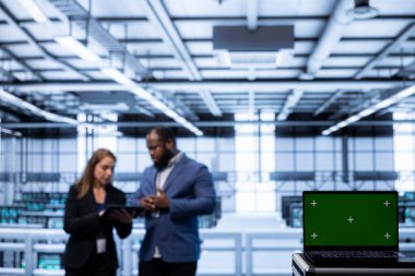 Veri merkezindeki iş arkadaşlarının siber güvenlik ve etkin ağ yönetimini sağlamak için kullandıkları model dizüstü bilgisayara odaklan. Veri merkezi ekipmanlarını optimize eden sunucu merkezindeki yeşil ekran defterini kapat