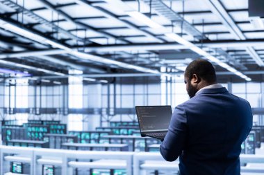 Veri merkezindeki yönetim veri merkezi sistemleriyle ilgili teknik arızaları tespit ediyor ve çözüyordu. İçerideki sunucu merkezi ve ana bilgisayar platformlarını yöneten, koruyan ve koruyan IT çalışanı