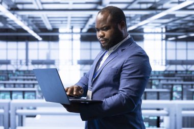 Veri merkezi izleme sistemi performansında yazılım geliştiricisi, darboğazları tanımlıyor ve optimizasyonları uyguluyor. Yüksek teknoloji sunucu merkezi çalışma alanı sorun giderme hatasında denetleyici