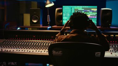 Afro-Amerikan ses mühendisi kayıt ve montaj parçalarını düğme ve şalterlerle karıştırarak post prodüksiyon yapıyor. Stüdyoda yeni müzik yapan yetenekli bir ses teknisyeni. Kamera B.