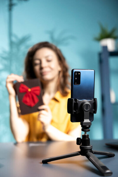 Сосредоточьтесь на смартфоне, используемом vlogger для записи раздачи зрителям, предлагая подарок на вождение помолвки. Закрытие телефона, используемого создателем контента для записи конкурса, с предложением приза