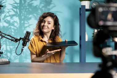 Gülümseyen teknoloji içeriği yaratıcısı yeni başlatılan ince oyun dizüstü bilgisayarının eleştirisini kaydediyor. Neşeli internet yıldızı, abonelere dizüstü bilgisayar sunuyor, ne kadar şık olduğundan etkilenmiş.