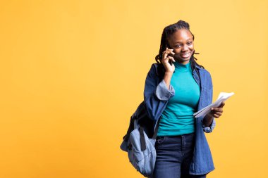 Afrikalı Amerikalı bir kız iş arkadaşıyla telefon görüşmesi yapıyor, okul ödevlerini tartışıyor, stüdyo geçmişinde izole edilmiş. Üniversite ders belgesi tutan öğrenci, telefonda sohbet ediyor.