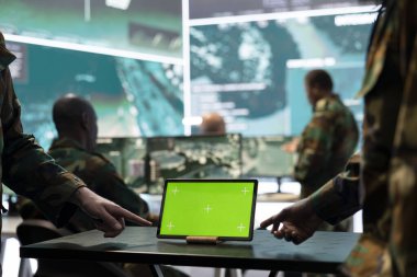 İki asker yeşil ekran modeli olan bir ekipte çalışıyor. Güç üssü komuta merkezinde askerlere yardım etmek için tablet kullanıyorlar. Askerler cihazdaki gerçek zamanlı bilgileri inceliyorlar. Kapat..