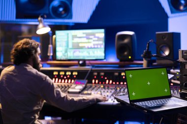 Ses yapımcısı, kontrol odasındaki monitörde izole bir şekilde çalışıyor. Profesyonel stüdyoda yeni müzik kaydediyor ve düzenliyor. Yetenekli teknisyen şarkıları konsolla karıştırıp ustalaştırıyor.