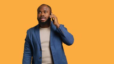 Olumlu duyguları olan neşeli bir adam, arkadaşlarıyla konuşmaktan zevk alan akıllı telefon kullanan, stüdyo geçmişi olan. Telefon görüşmesi sırasında gülümseyen mutlu Afro-Amerikalı kişi, kamera A