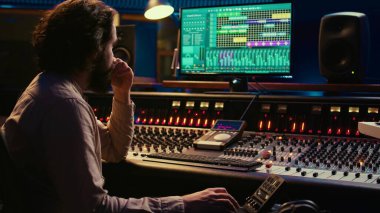 Ses tasarım işleme ve karıştırma melodileri kontrol odasında, profesyonel kayıt stüdyosunda yeni bir albüm üzerinde çalışıyor. Ses uzmanı düğmeleri ve kaydırıcıları olan kontrol paneli kullanıyor. Kamera B.