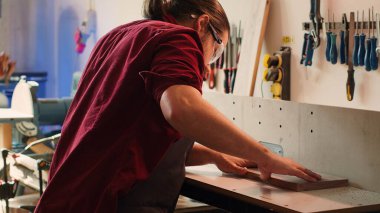 Arkaplanda iş arkadaşı olan özel yapım bir marangozluk yaratmak için odun işçisi işletiyor. Üretici ve BIPOC çırağı ahşap şekillendirici, şekil verme ve kesme işleri yapıyor, kamera A