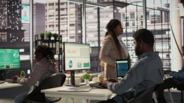 Erkek yönetici analist finansal bir rapor hazırlar ve verileri gözden geçirir, örgütsel ilerleme için bir öngörü geliştirir. Siyahi adam görev yönetimi ve strateji planlaması yapıyor. Kamera B.