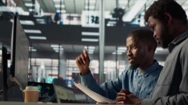 İşletme müdürü, bilgisayar hakkındaki mali tahminleri gözden geçirmek için bir işçiyle birlikte oturuyor ve proje geliştirme hakkında bir analitik değerlendirmeye öncülük ediyor. Gelişim için organizasyonel hedeflere ulaşmak. Kamera A.