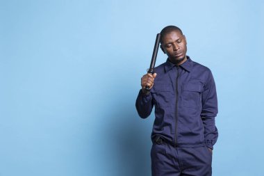 Afro-Amerikan güvenlik görevlisinin portresi savunma ve koruma için acil durumlar için copunun üzerine asılıydı. Erkek ajan dövüşte yetenekli, yeteneklerine güveniyor..