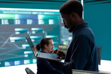 Hükümet hackerları ağ güvenliğini gelişmiş tekniklerle ve siber savunmayla aşıyor. Bilgi toplamak için bilgi toplamaya çalışan bilişim uzmanları ekibi, büyük ekran.