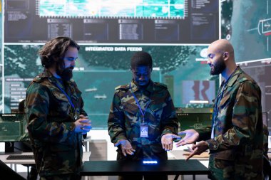 Bir güç üssünde istihbarat toplayan çeşitli askerlerden oluşan bir ekip sahadaki piyade birliklerine yardım etmek için bir hologram projeksiyonunun kamera görüntülerini inceliyor. Eğitimli askerler gerçek zamanlı veri çalışırlar..