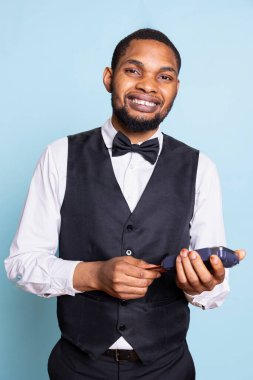 Afro-amerikan belboyu posizyon terminalini işaret ediyor ve ödeme istiyor, hizmet odaklı konukseverlik endüstrisi. Konaklama için elektronik aktarımın sembolü.