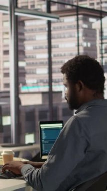 Dikey Video Afrikalı Amerikalı bir şirket çalışanı, rahatsız bir sandalye ve yanlış bir duruşla çalıştıktan sonra ağrısını hafifletmek için ofiste biraz ara veriyor. İltihap.