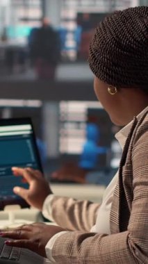 Ofis masasındaki dikey video özgüveni olan iş kadını rapor yazma ve cevap yazma, idari işler yönetimi üzerinde çalışıyor. Siyahi kadın uzman başarıyı garanti altına almak için hedefleri gözden geçiriyor