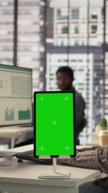 Vertical Video Kadın Yöneticisi, yeşil ekranlı çalışma istasyonunda oturmuş, işletme büyümesi için idari görevleri çözmeye çalışıyor. Şirket hedeflerini desteklemek için performans ölçümleri geliştiriliyor