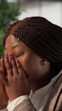 Dikey Afrikalı Amerikalı yorgun iş adamı şirket hedeflerine ulaşmak için çok çalışıyor, hedeflere ulaşmanın getirdiği baskıyı ve yorgunluğu hissediyor. Genç bayan yönetici yorgun hissediyor.