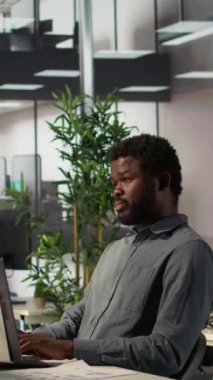 Dikey Video Afrikalı Amerikalı analist hissedarlarla aylık gelirleri tartışıyor, video konferansına katılıyor, uzaktan görüşme yapıyor. Girişimci daha fazla fon ve çevrimiçi iletişim istiyor