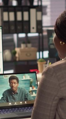 Dikey Video Siyah Direktörü, yeni bir strateji için iş danışmanlarıyla yaptığı bir video görüşmesinde, hedefler belirlemek için çevrimiçi konferansta uzaktan iletişimi kullanıyor. Uzmanla bağlantı