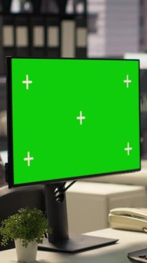 Ofis masasındaki Dikey Video İşkadını, etkili karar verme ve şirket hedeflerini desteklemek amacıyla cihazdaki yeşil ekrana bakıyor, belgeler ve bilgi grafikleri üzerinde çalışıyor. İdari görevler