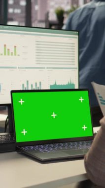 Dikey Video Şirketi çalışanı, iş amaçlarına ulaşmak için yeşil ekranın yanındaki stratejik planlamaya odaklandı. Kadın danışman bütçe analizi ve performans ölçümleri ile ilgileniyor